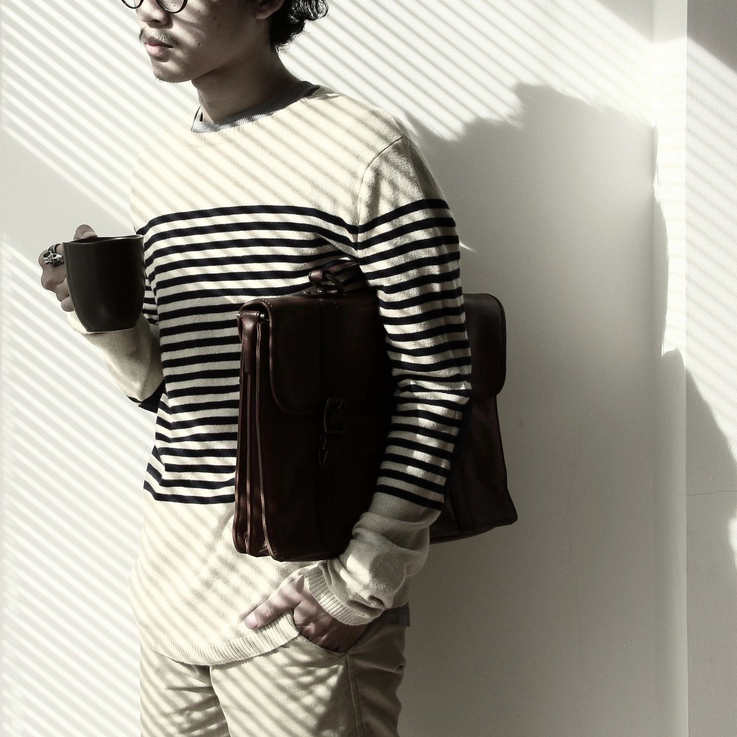 New employee standing with a coffee and folder, uncertain about what they should be doing